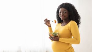 mulher grávida comendo alimentos saudáveis